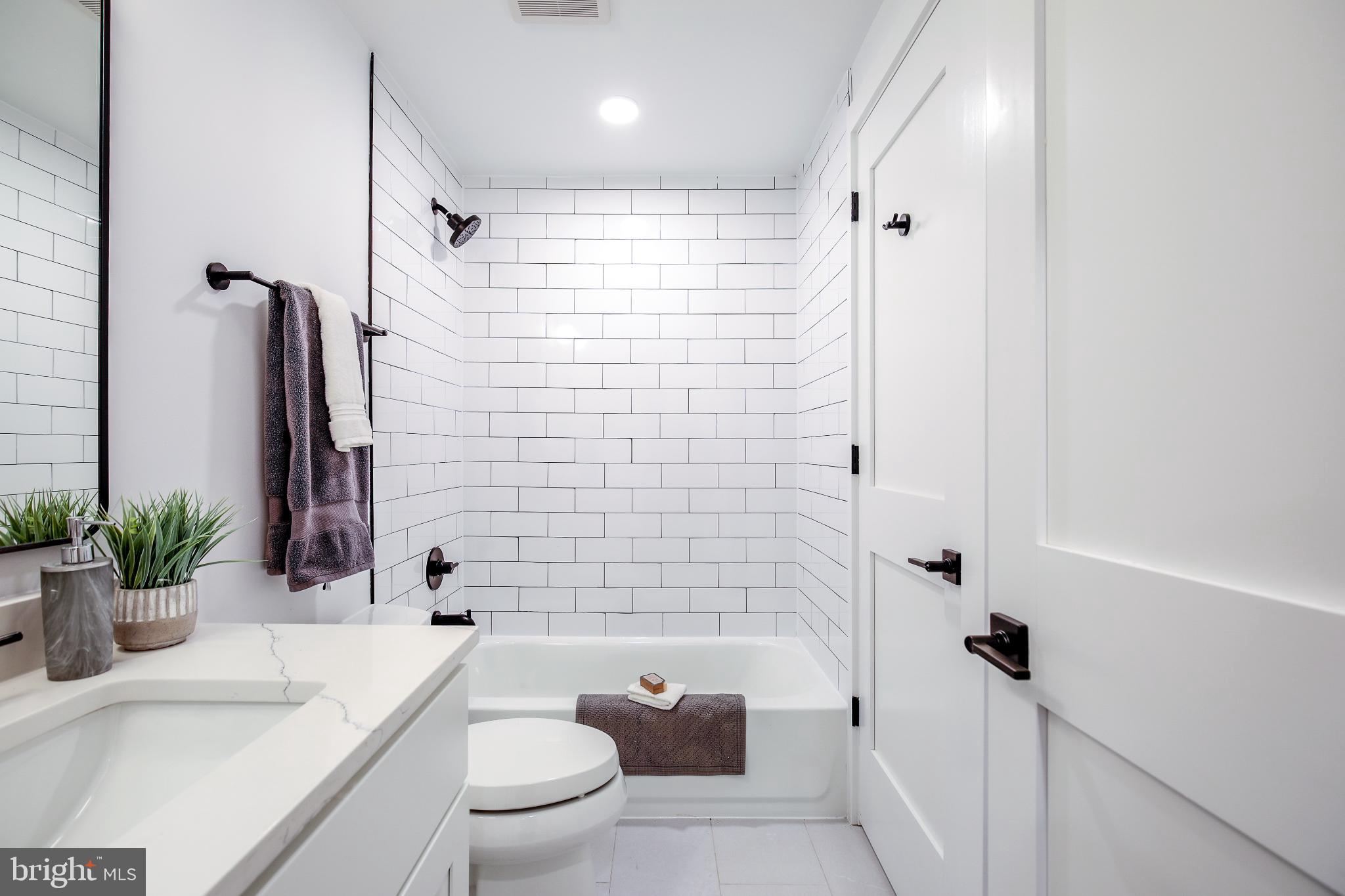 1009 Rhode Island Avenue Northeast, Unit 1 Washington, DC 20018 - Photo 17 of 21 a bathroom with a sink a toilet a tub and shower