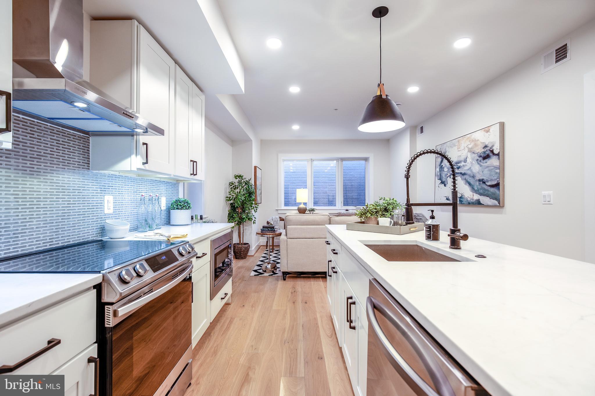 1009 Rhode Island Avenue Northeast, Unit 1 Washington, DC 20018 - Photo 3 of 21 a kitchen with a sink stove and cabinets