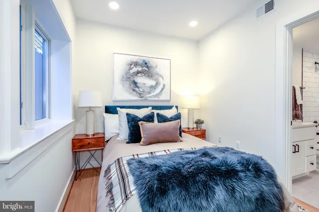 a bedroom with bed and paintings on the wall