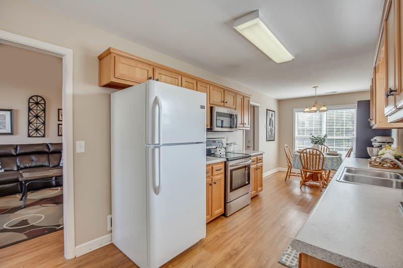 2242 Dewey Drive Spring Hill, TN 37174 - Photo 12 of 29 a kitchen with stainless steel appliances granite countertop a refrigerator a stove a sink a dining table and chairs with wooden floor