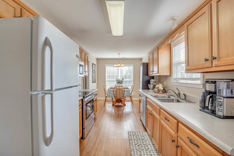 2242 Dewey Drive Spring Hill, TN 37174 - Photo 13 of 29 a kitchen with stainless steel appliances a refrigerator a sink a stove and white cabinets with wooden floor