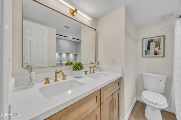 a bathroom with a granite countertop sink mirror vanity and toilet