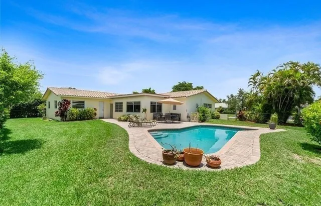 a view of a house with pool garden and chairs