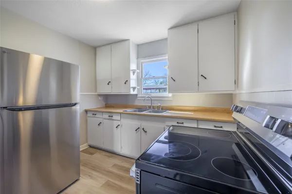 a kitchen with a refrigerator and white cabinets