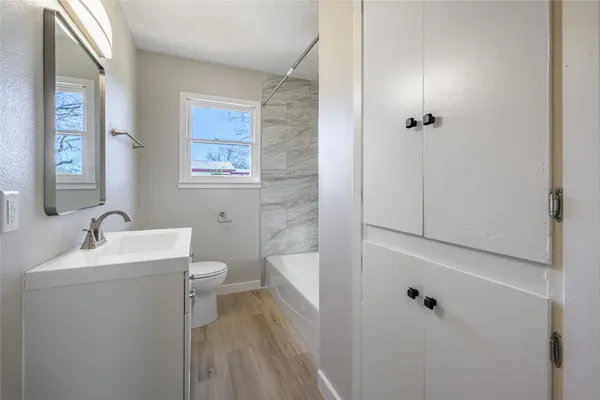a bathroom with a toilet a sink and mirror