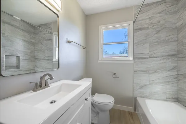 a bathroom with a sink a toilet and shower