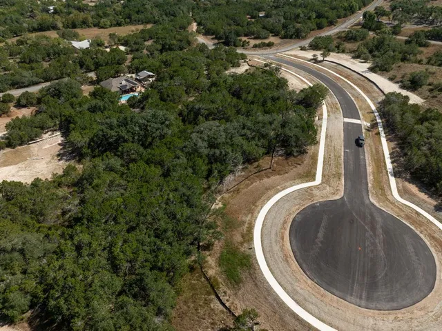 an aerial view of a house with a yard and lake view in back