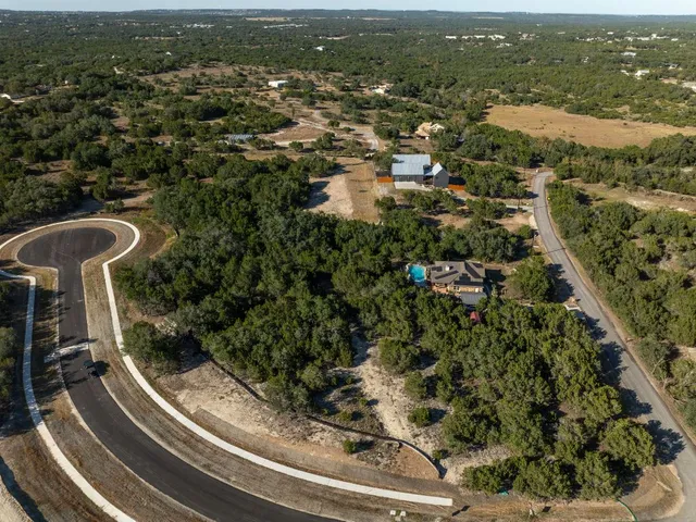 an aerial view of residential houses with outdoor space and trees