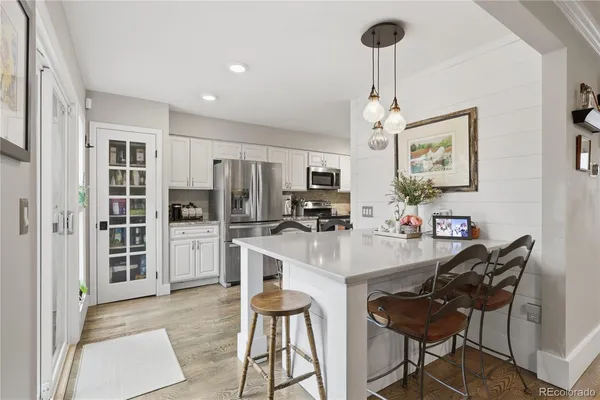a kitchen with stainless steel appliances kitchen island granite countertop a refrigerator and microwave