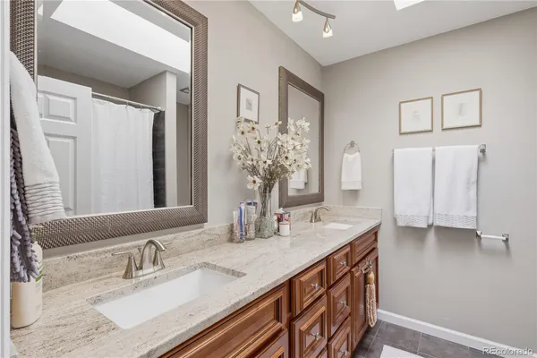 a bathroom with a granite countertop sink and a mirror