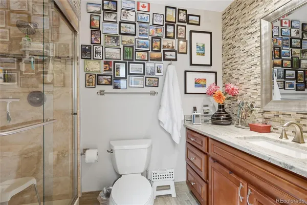 a bathroom with a granite countertop sink a toilet and shower