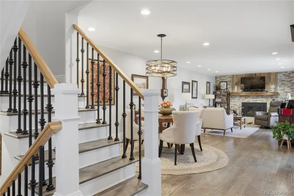 a view of a livingroom with furniture stairs a fireplace and wooden floor