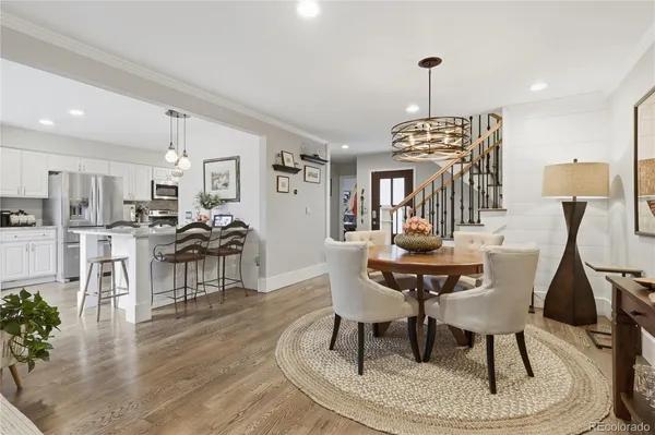 a dining room with furniture a chandelier and wooden floor