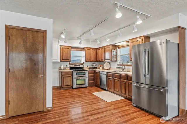 a kitchen with stainless steel appliances granite countertop a stove and a sink