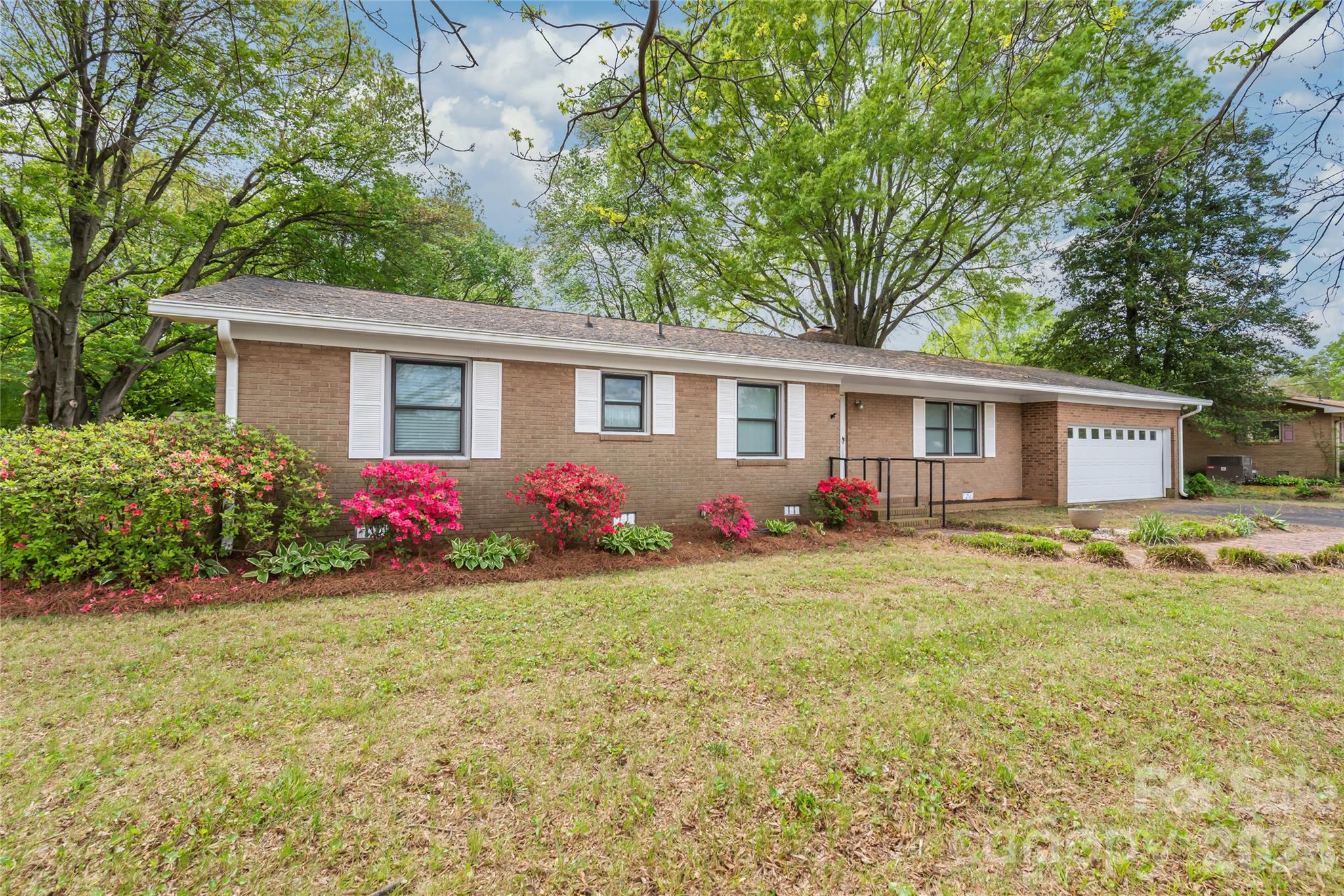a view of a house with a yard and a garden