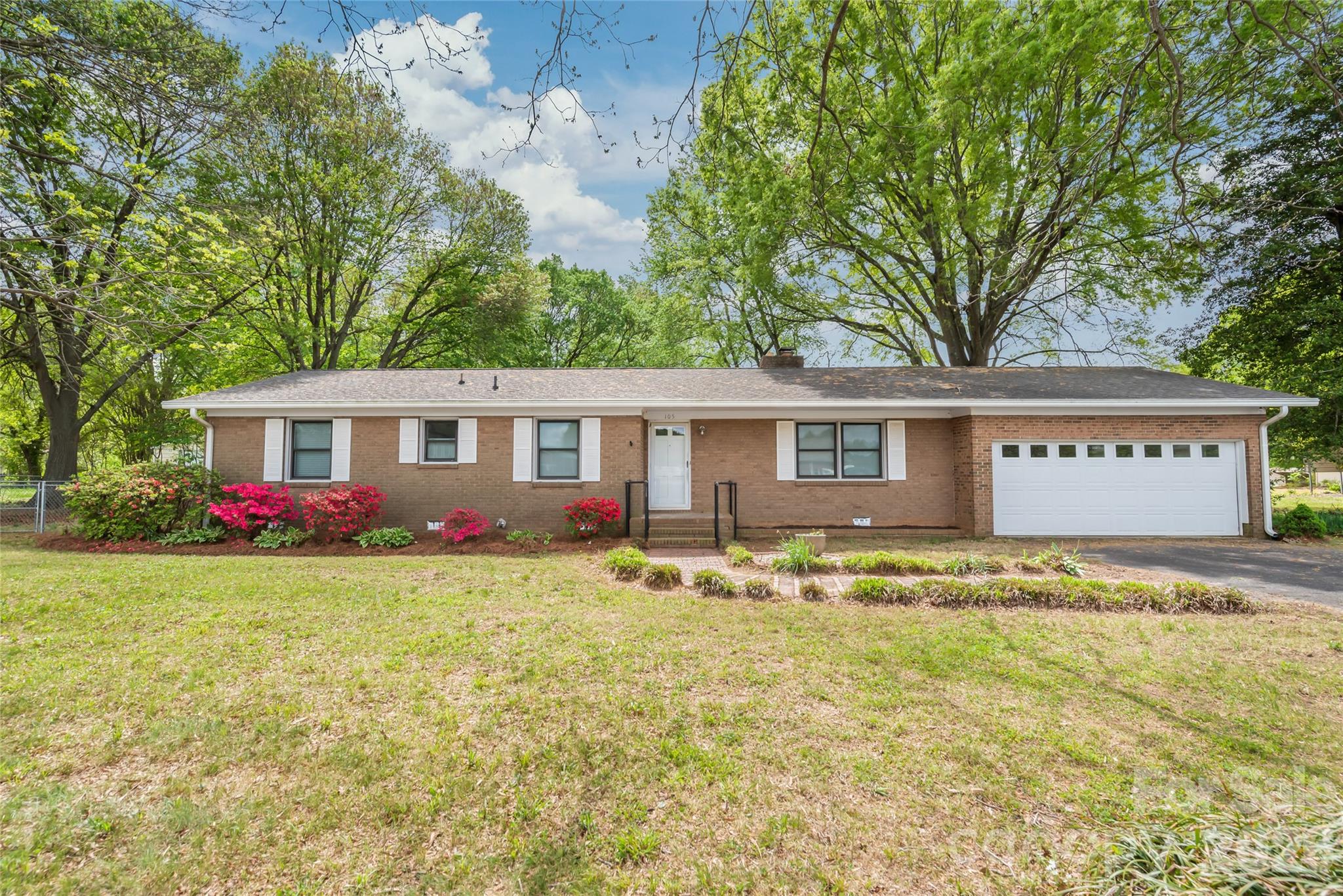 105 West Sunset Drive Locust, NC 28097 - Photo 2 of 24 a front view of a house with yard and garage