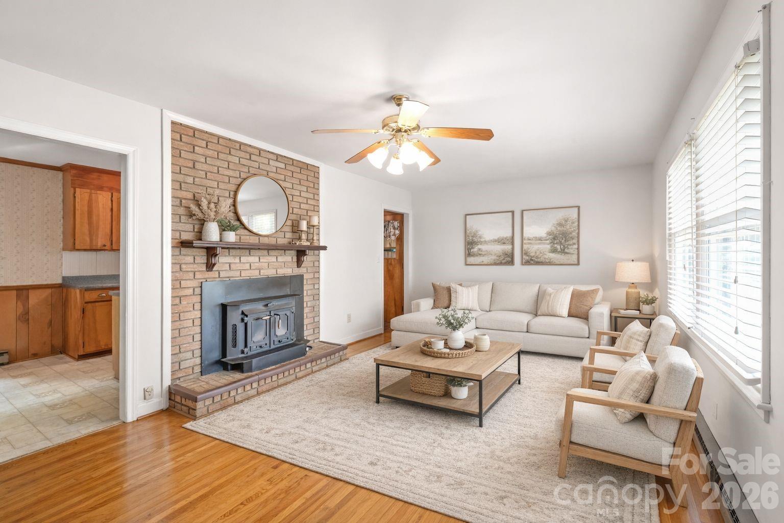 105 West Sunset Drive Locust, NC 28097 - Photo 4 of 24 a living room with furniture a fireplace with wooden floor and windows