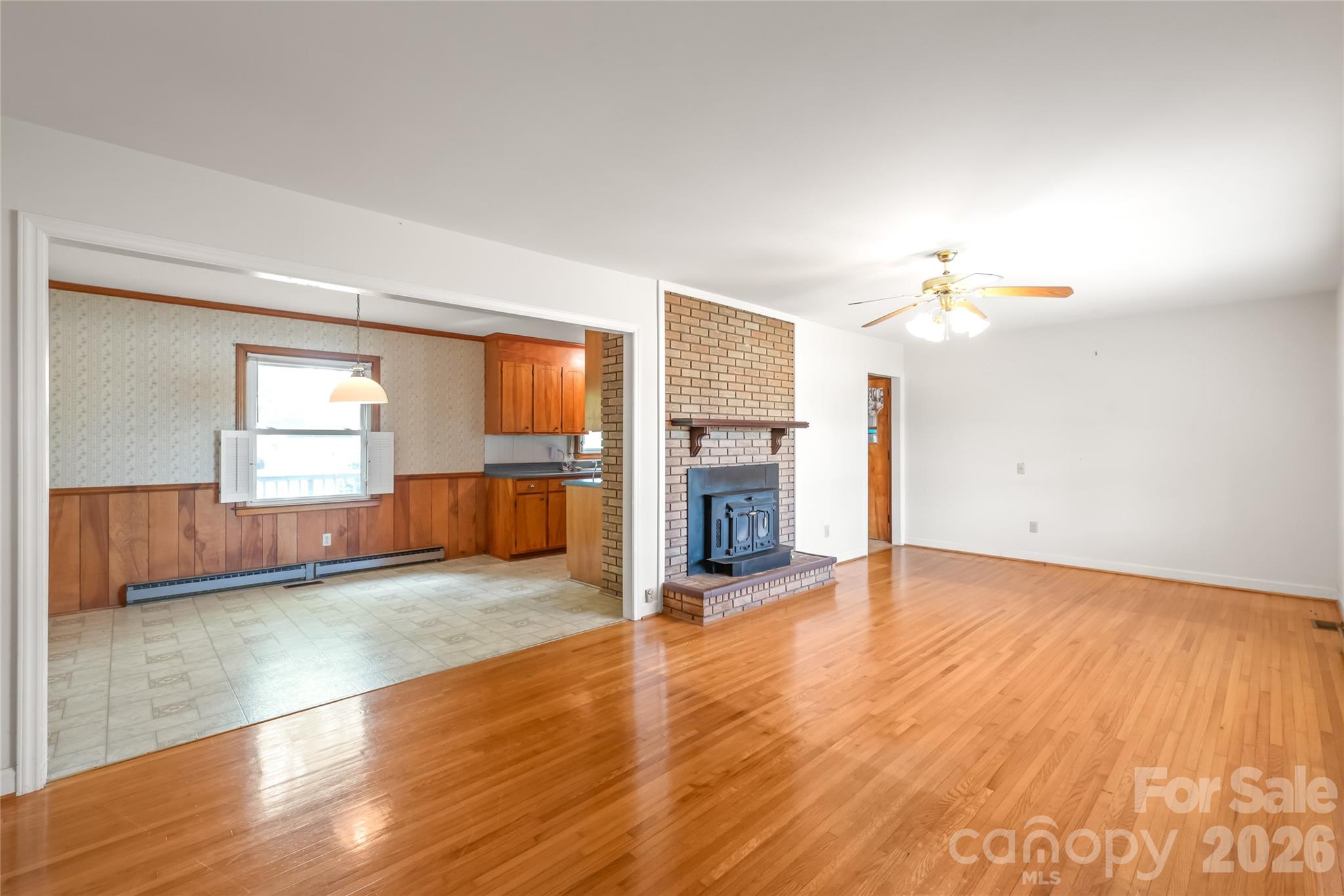 105 West Sunset Drive Locust, NC 28097 - Photo 5 of 24 an empty room with wooden floor fireplace and windows