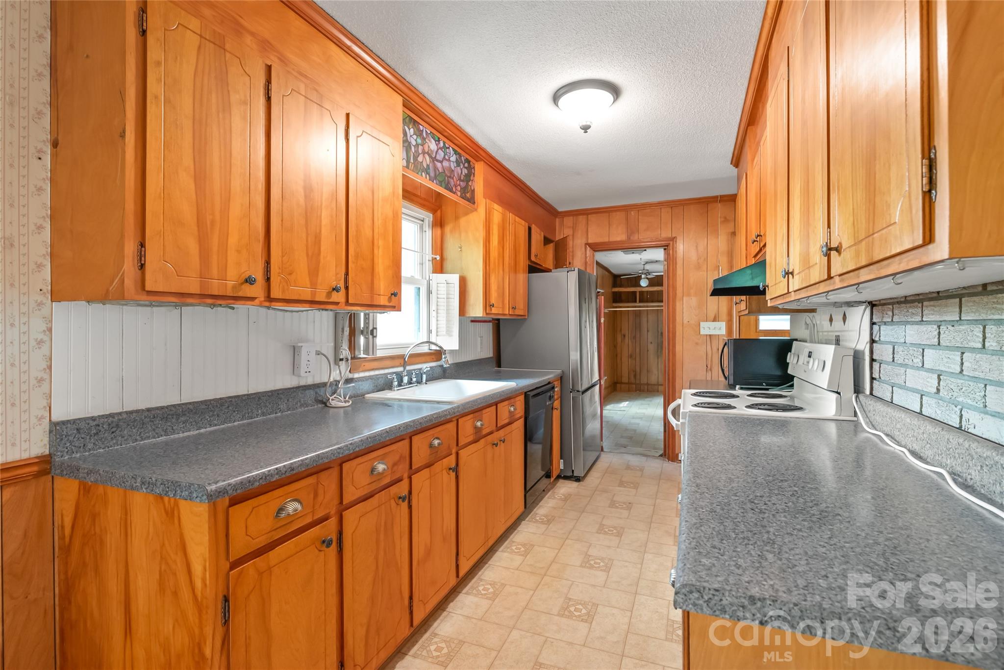 105 West Sunset Drive Locust, NC 28097 - Photo 9 of 24 a kitchen with stainless steel appliances granite countertop a stove a sink and a refrigerator