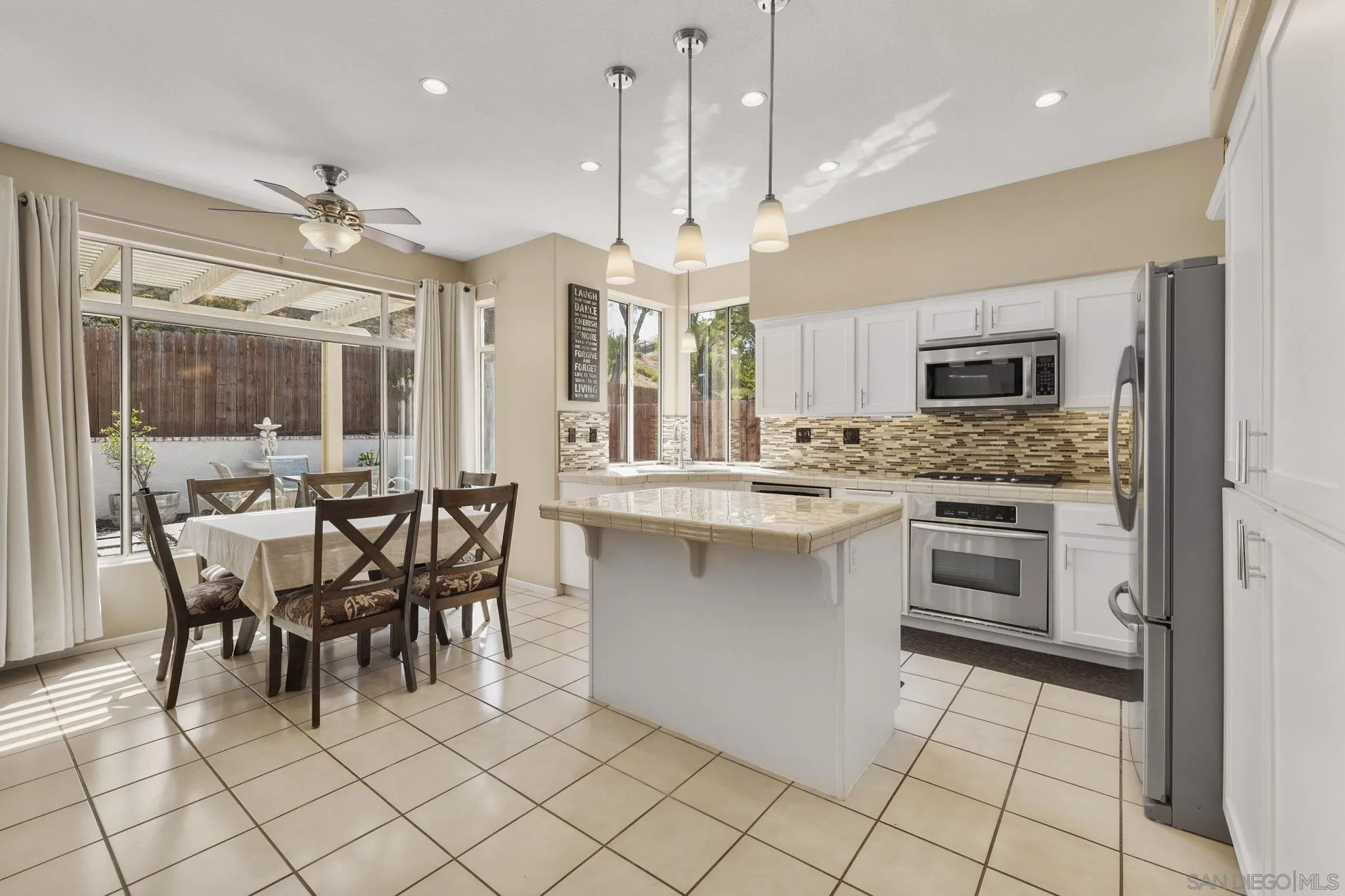 838 Masters Drive Oceanside, CA 92057 - Photo 12 of 39 a kitchen with stainless steel appliances granite countertop a stove top oven a sink dishwasher a dining table and chairs