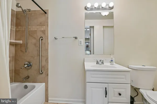 a bathroom with a sink a toilet a mirror and shower