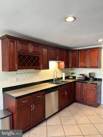 a kitchen with stainless steel appliances granite countertop wooden cabinets a stove top oven a sink and dishwasher