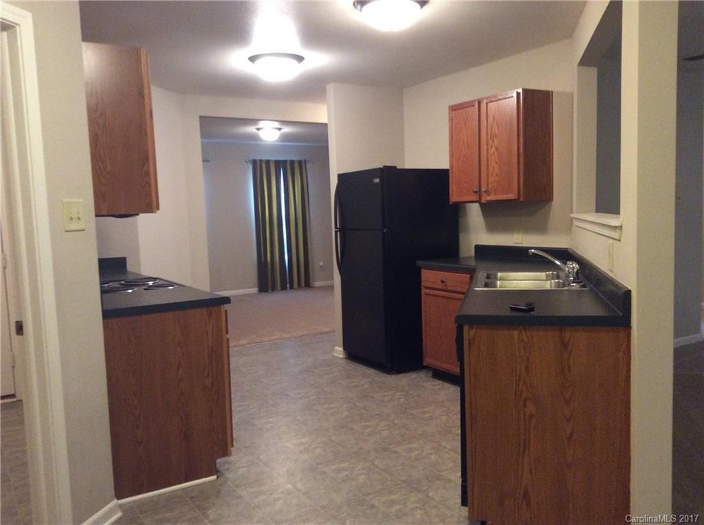 5409 Idlewild Road North Charlotte, NC 28227 - Photo 3 of 10 a kitchen with stainless steel appliances granite countertop a refrigerator a stove and a sink