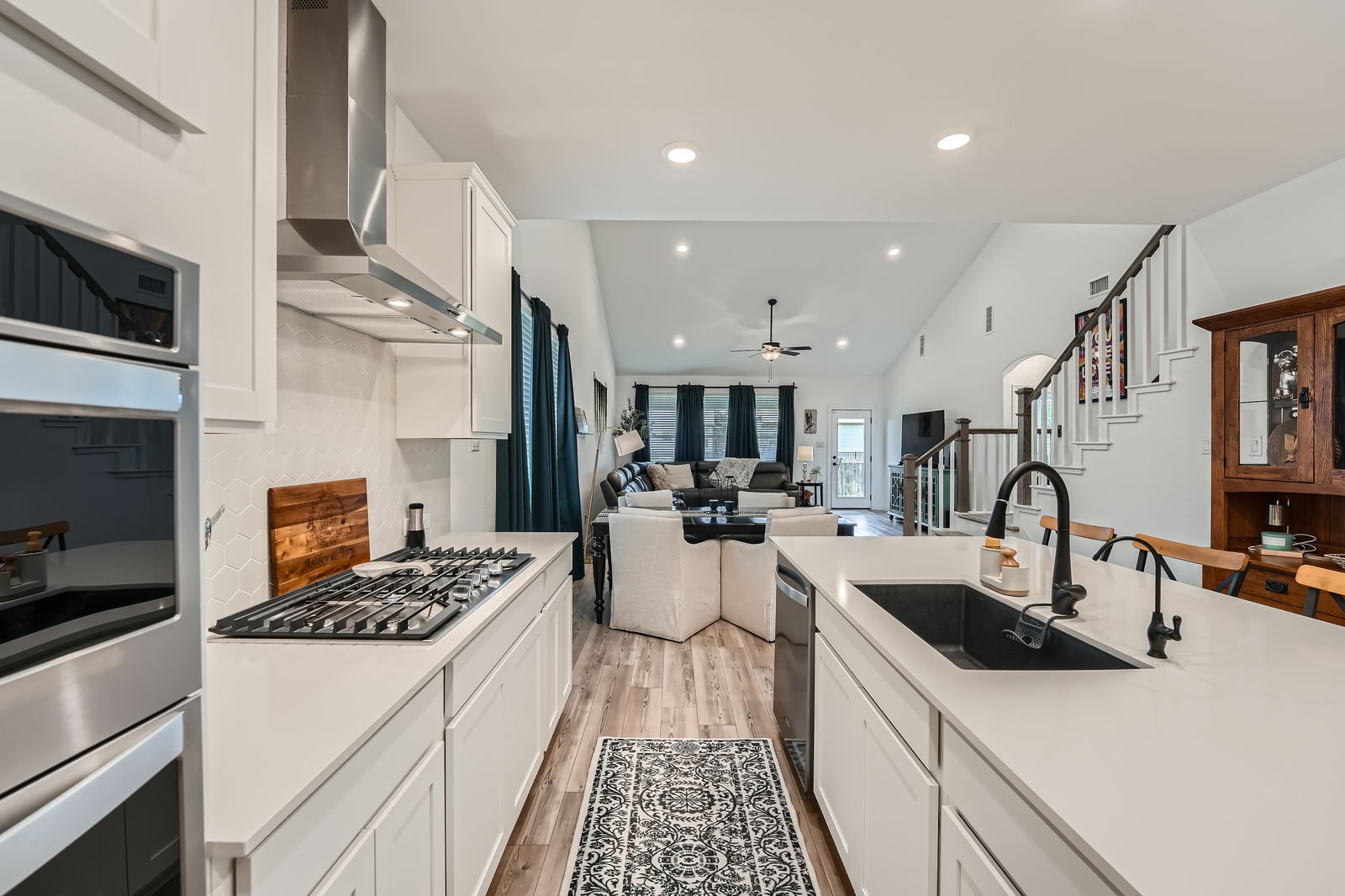 321 Georgia Lace Trail Georgetown, TX 78626 - Photo 27 of 27 Kitchen featuring white cabinetry, open floor plan, light wood finished floors, appliances with stainless steel finishes, and wall chimney exhaust hood