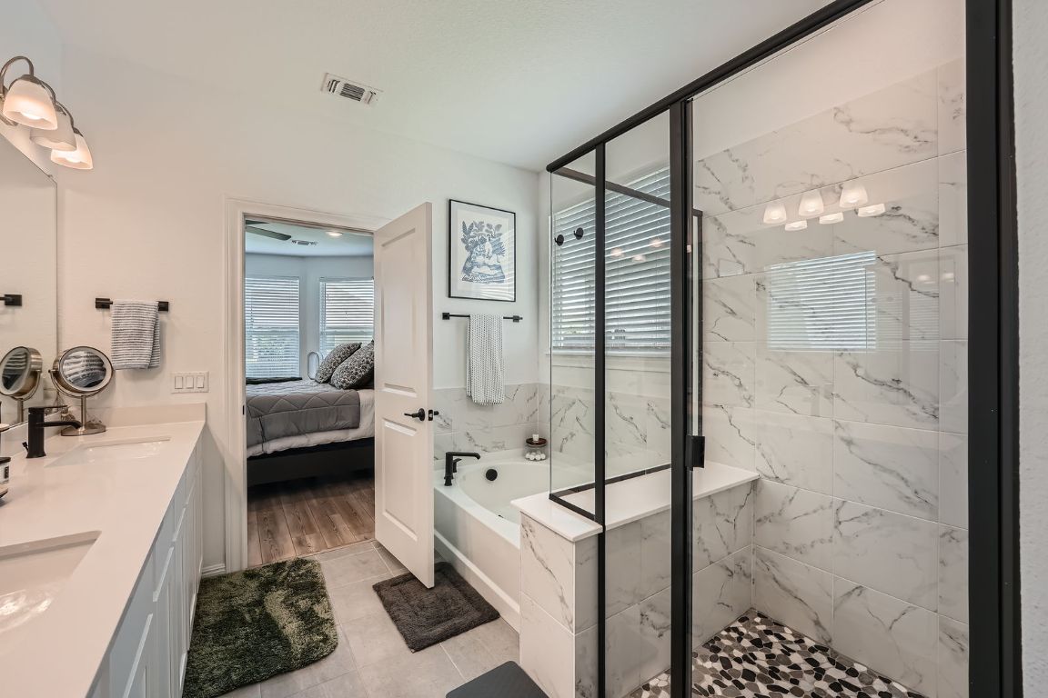 321 Georgia Lace Trail Georgetown, TX 78626 - Photo 16 of 28 Bathroom with ensuite bathroom, a bath, a marble finish shower, and double vanity