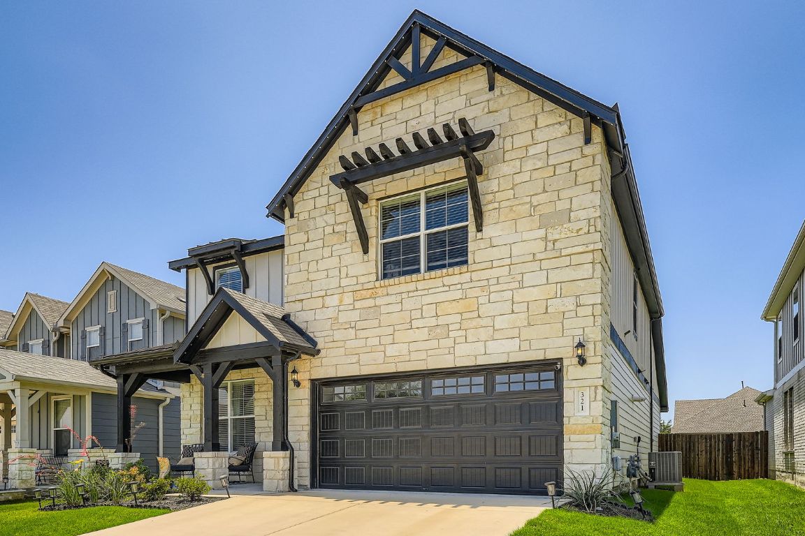 321 Georgia Lace Trail Georgetown, TX 78626 - Photo 2 of 28 Craftsman-style house with stone siding, a garage, driveway, board and batten siding, and covered porch