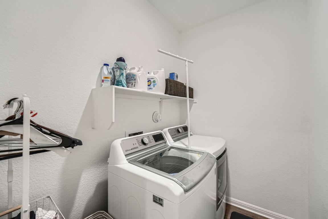 321 Georgia Lace Trail Georgetown, TX 78626 - Photo 22 of 28 Laundry room featuring washer and clothes dryer and a textured wall