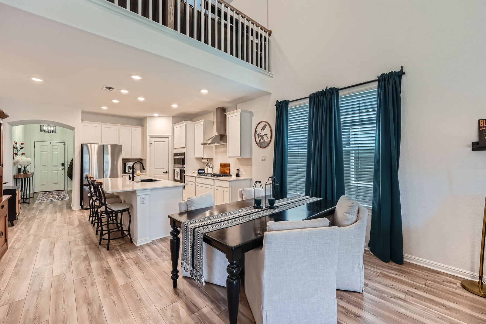 321 Georgia Lace Trail Georgetown, TX 78626 - Photo 7 of 27 Dining area with light wood-style floors, recessed lighting, arched walkways, and a towering ceiling