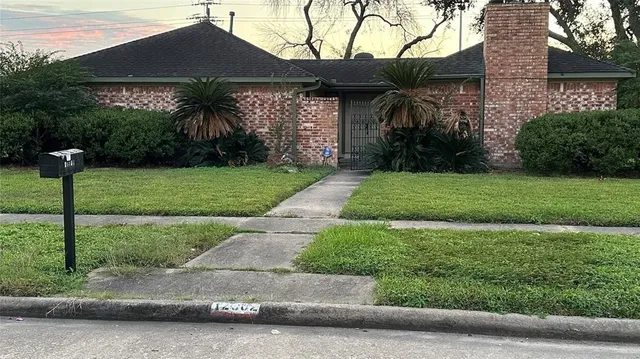 a view of a house with a yard and potted plants