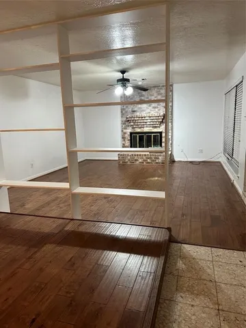 a view of room with wooden floor and fan
