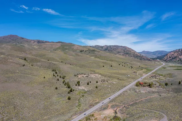 a view of a dry field with mountains in the background