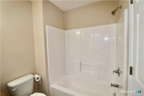a bathroom with a granite countertop bathtub shower and toilet