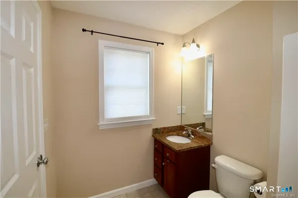a bathroom with a toilet sink vanity and mirror