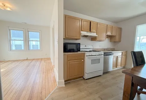 a kitchen with white cabinets and white appliances