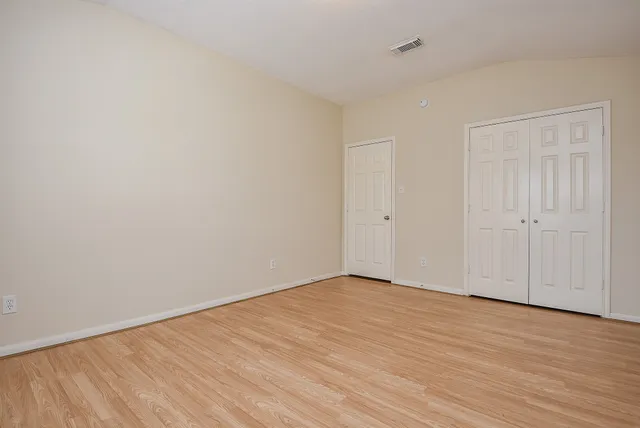 a view of an empty room with wooden floor