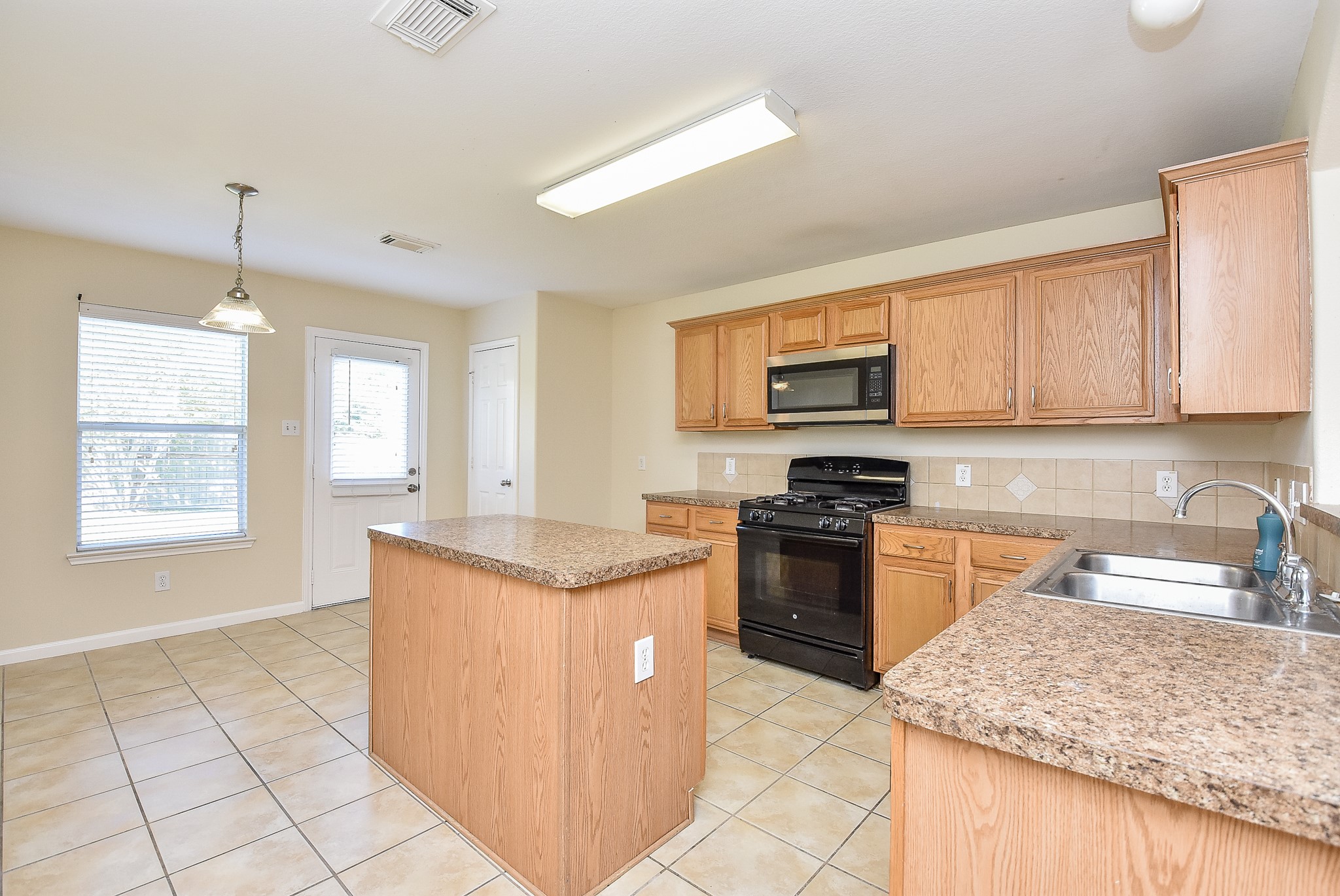 23527 Maple View Drive Spring, TX 77373 - Photo 7 of 25 a kitchen with stainless steel appliances granite countertop a stove top oven a sink a counter top space and cabinets