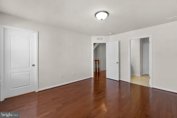 a view of an empty room with wooden floor