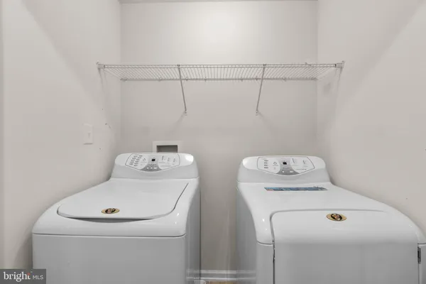 a view of an empty room with wooden floor and a ceiling fan
