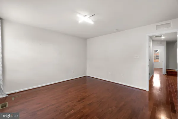 a view of an empty room with wooden floor