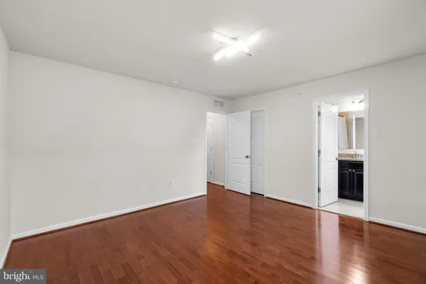 a bathroom with a granite countertop sink vanity mirror and toilet