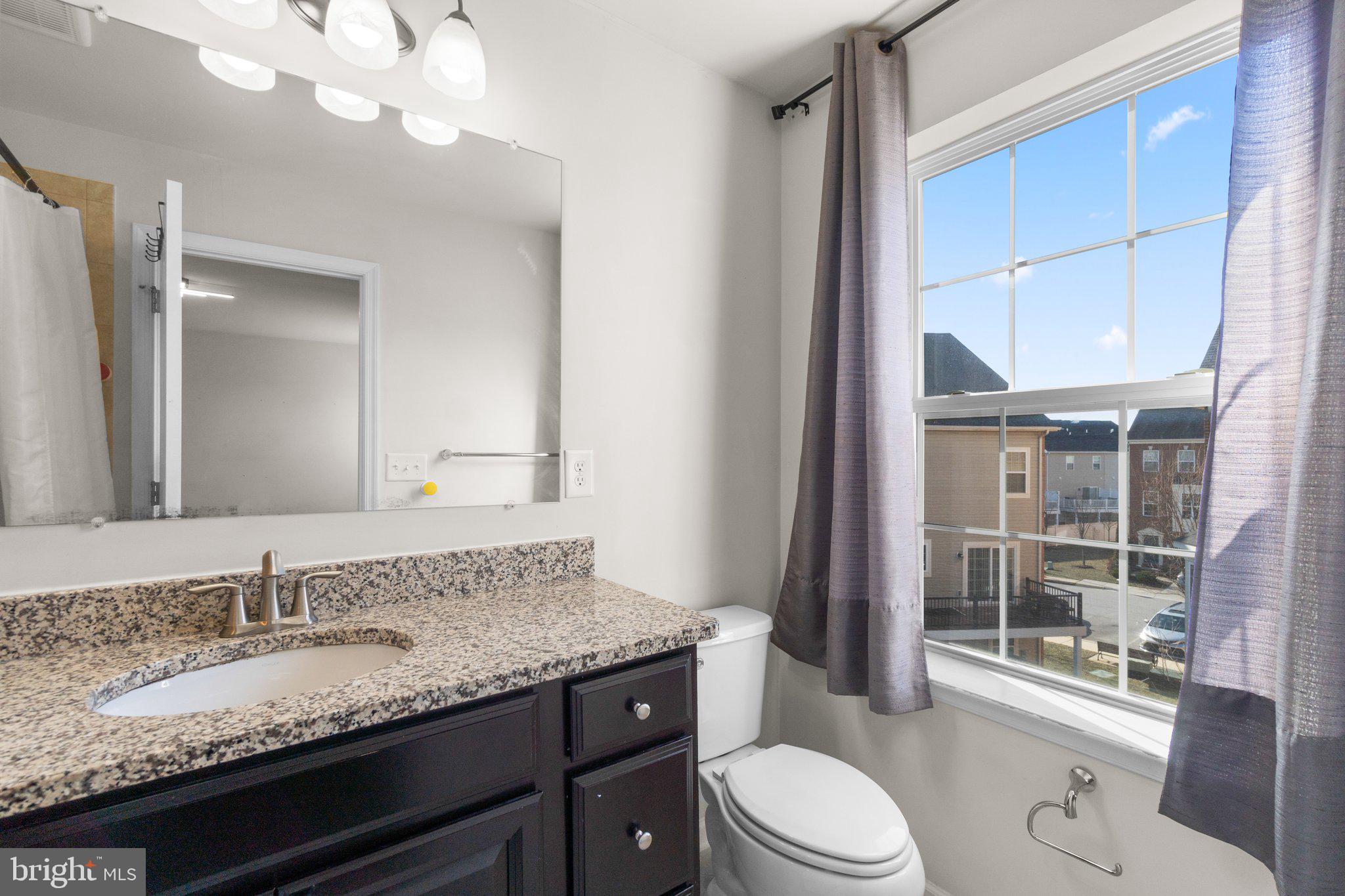 8020 Ravenclaw Road Elkridge, MD 21075 - Photo 20 of 38 a bathroom with a granite countertop sink vanity mirror and toilet