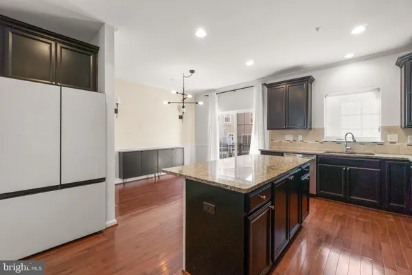 a kitchen with granite countertop a sink and a refrigerator