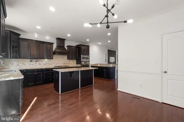 a large kitchen with a center island appliances and cabinets