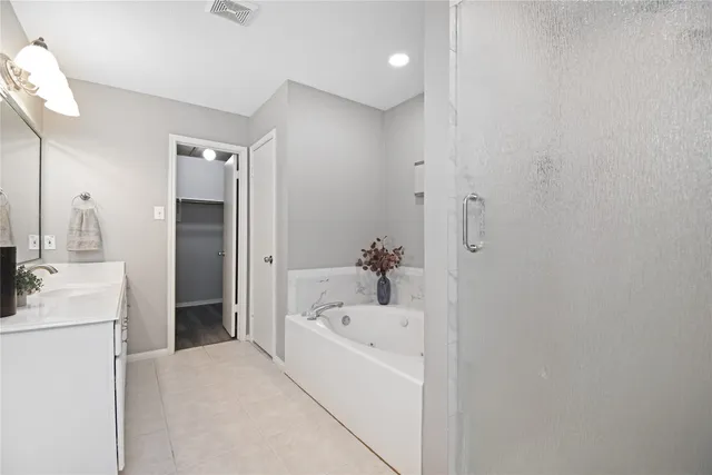 a bathroom with a bathtub sink and mirror