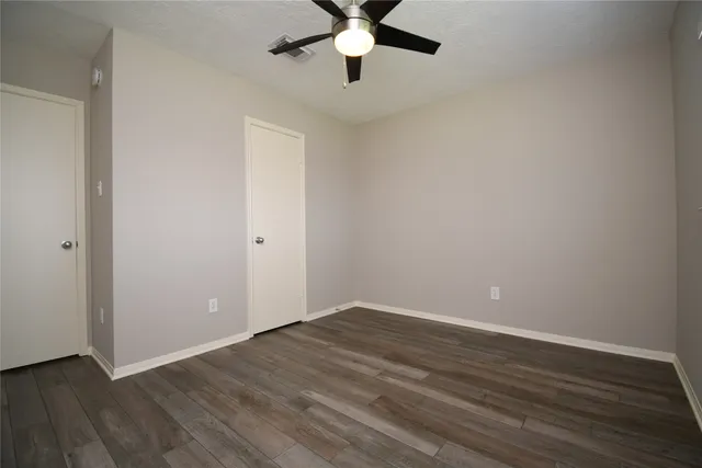 a view of an empty room with wooden floor