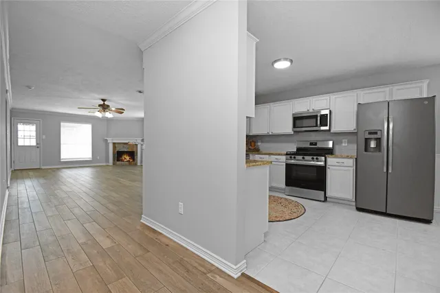 a kitchen with granite countertop a refrigerator and a stove top oven